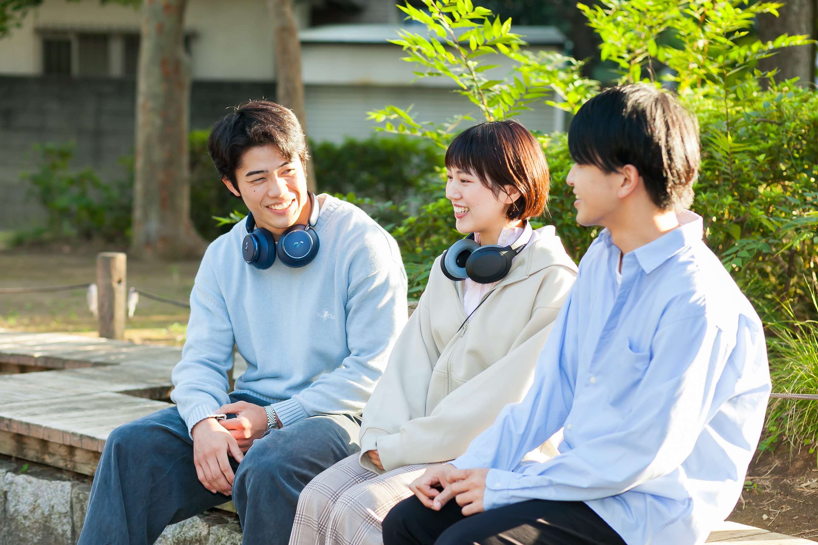 屋外で話す三人の様子