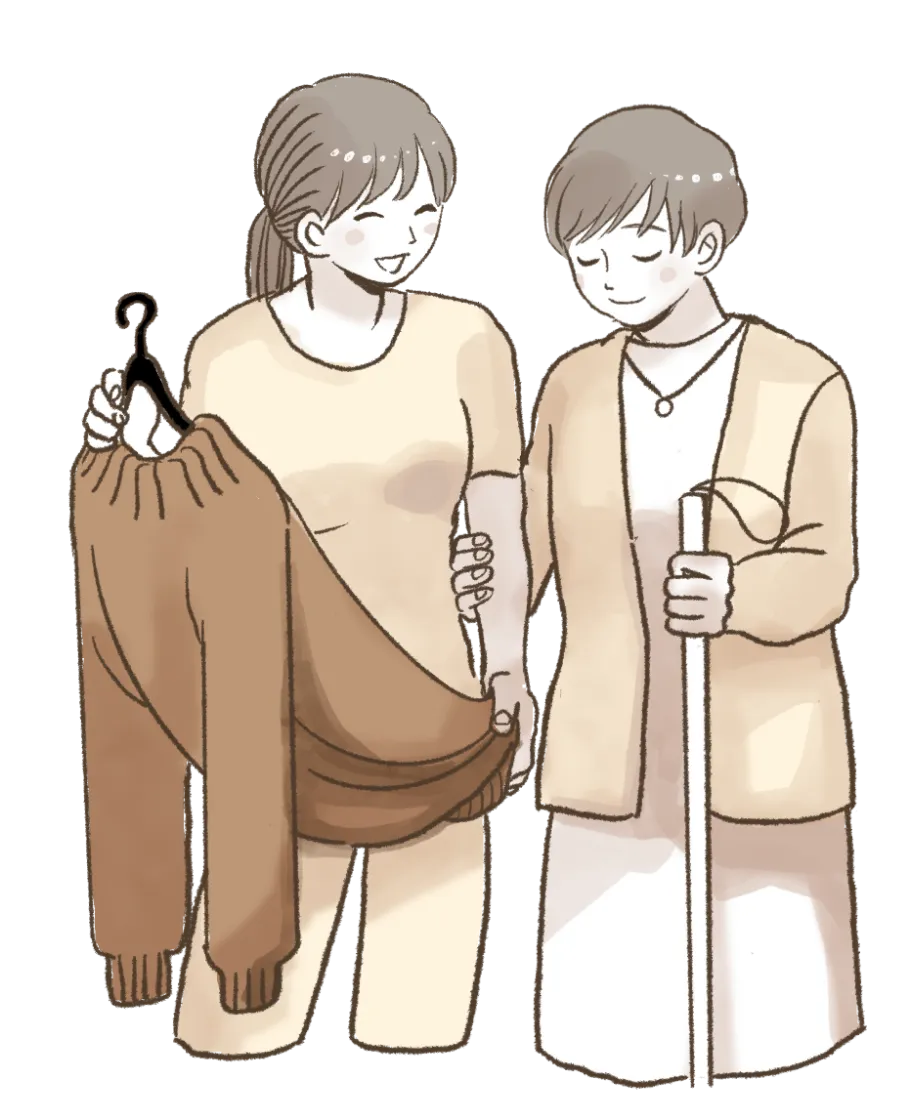 白杖を持った女性と女性のヘルパー洋服を選んでいる様子