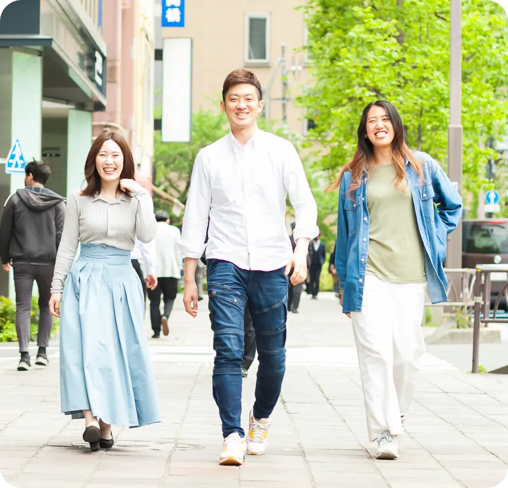 ヘルパー3名が笑顔で街なかを歩いている様子