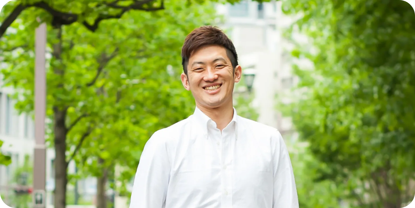 代表取締役の高橋昌希が笑顔で立っている様子